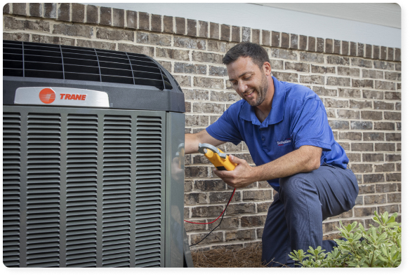 Technician In A Blue Shirt Checking An Outdoor Air Conditioning Unit Next To A Brick Wall Using A Testing Device.